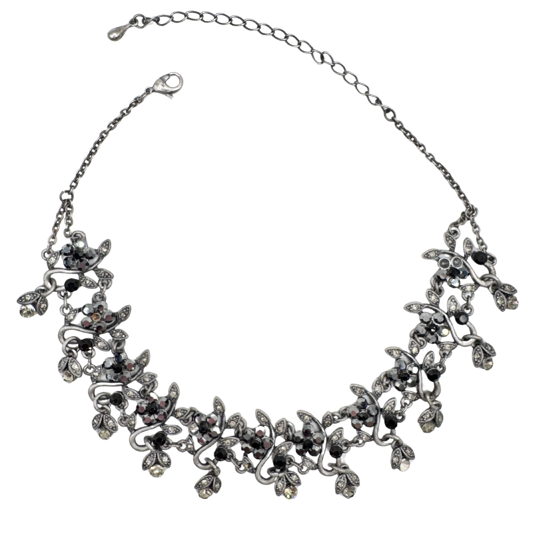 Vintage floral statement necklace with faux hematite, black and clear gemstones set in sterling silver plated base metal.